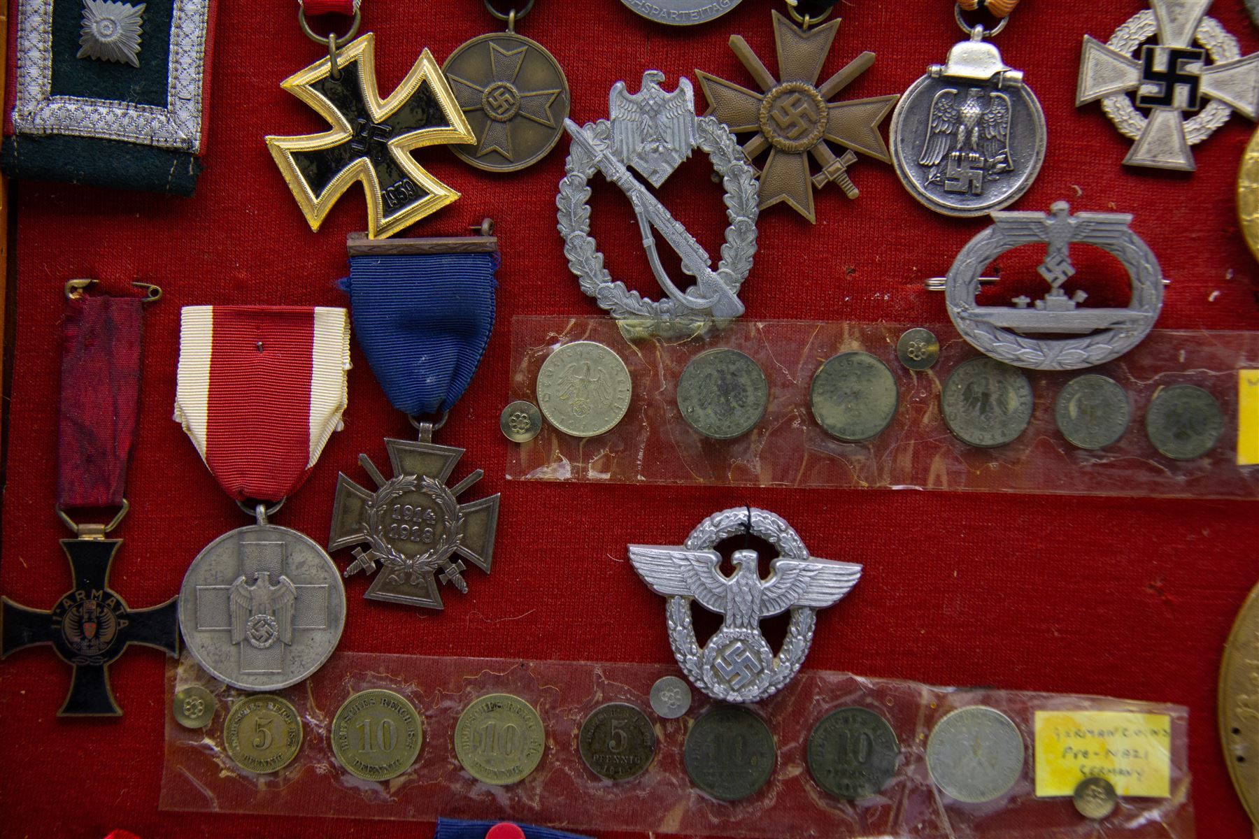 European and World medals and replicas, Italian Commemorative Cross of the 11th Army, German Cross of Honor, Pakistan 1948 general service medal, Belgium Commemorative medal, together with German coins, badges etc, all within a framed display, H29cm, W38cm 