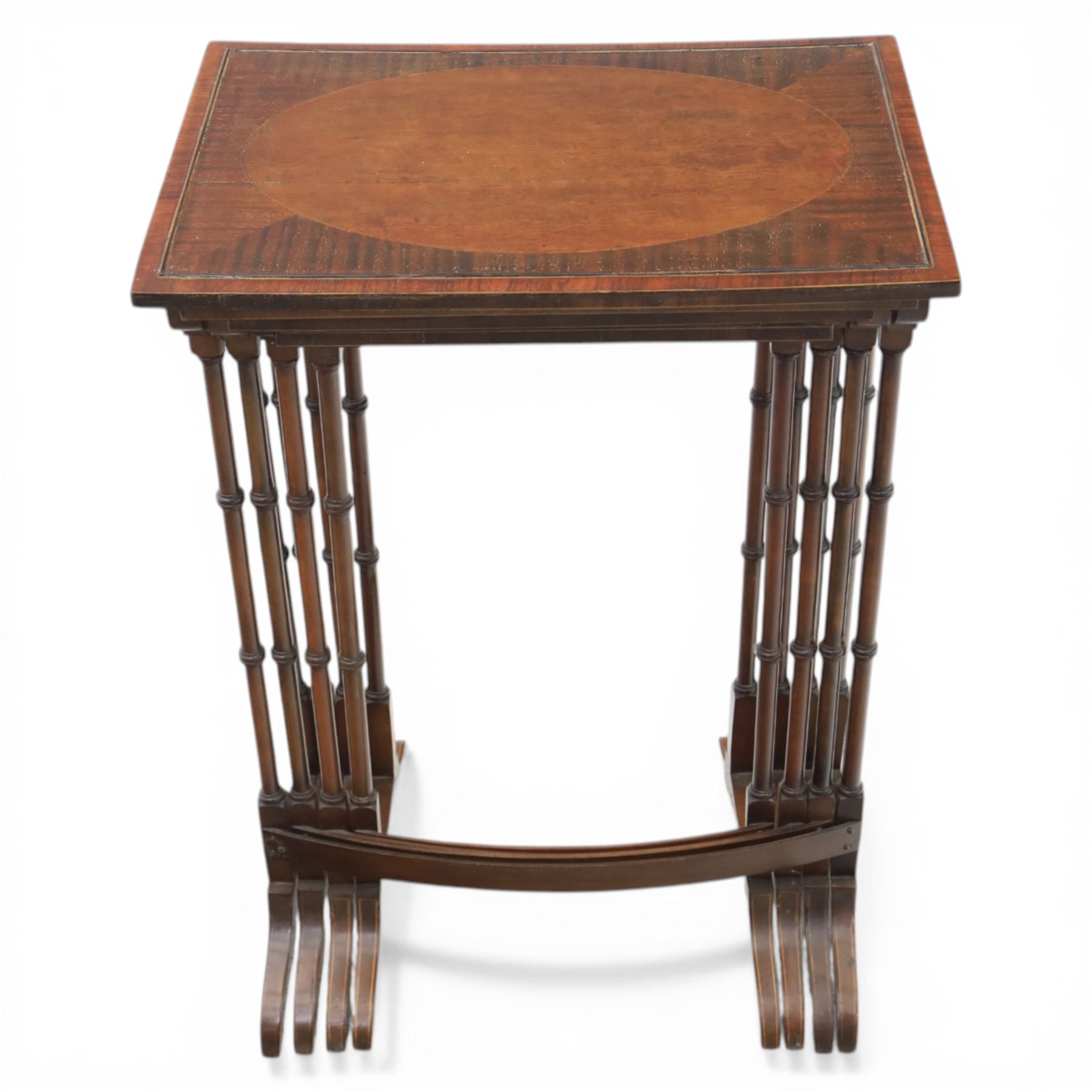 20th century mahogany quartetto nest of tables, the rectangular tops with oval inlay, upon turned knopped supports, united by a curved stretcher, raised upon outswept feet