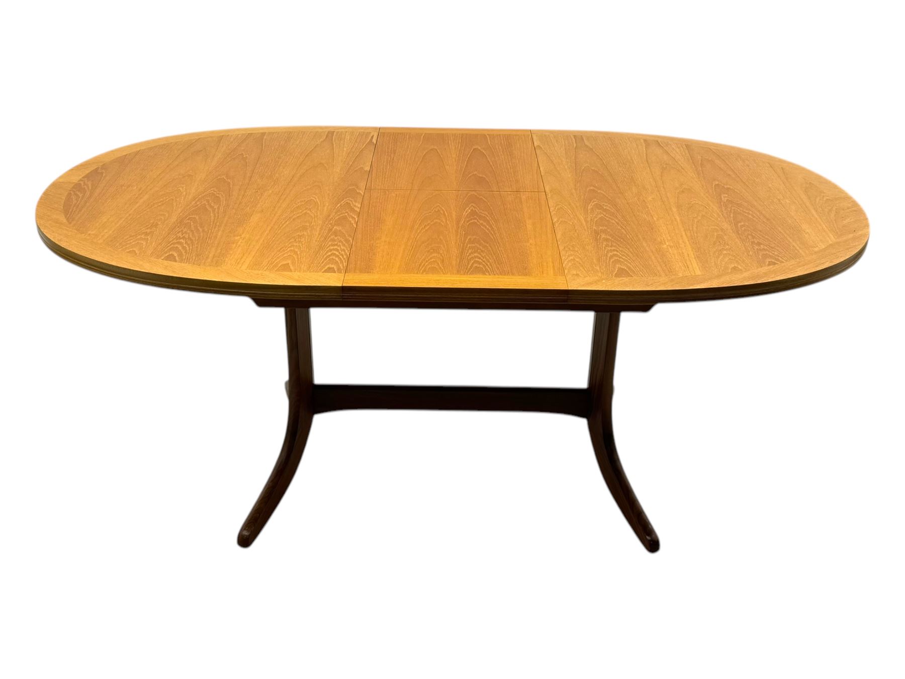 G-Plan - mid-20th century teak extending dining table, oval top with concealed central butterfly leaf extension, raised on splayed supports with cross-stretcher; three dining chairs with curved top rail and vertical splats