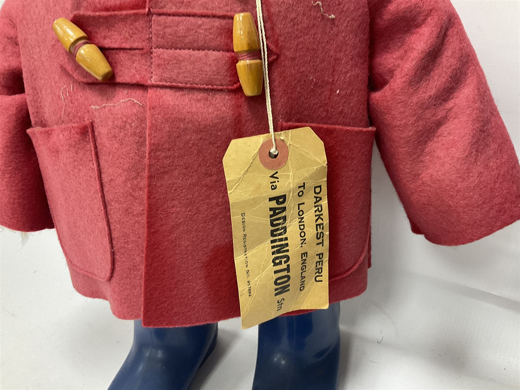 Pair of Paddington Bear teddies with amber eyes, the first example having a brown felt hat, red coat and blue PB boots with original label; the second having a grey felt hat, blue coat and blue Dunlop boots, tallest H51cm 