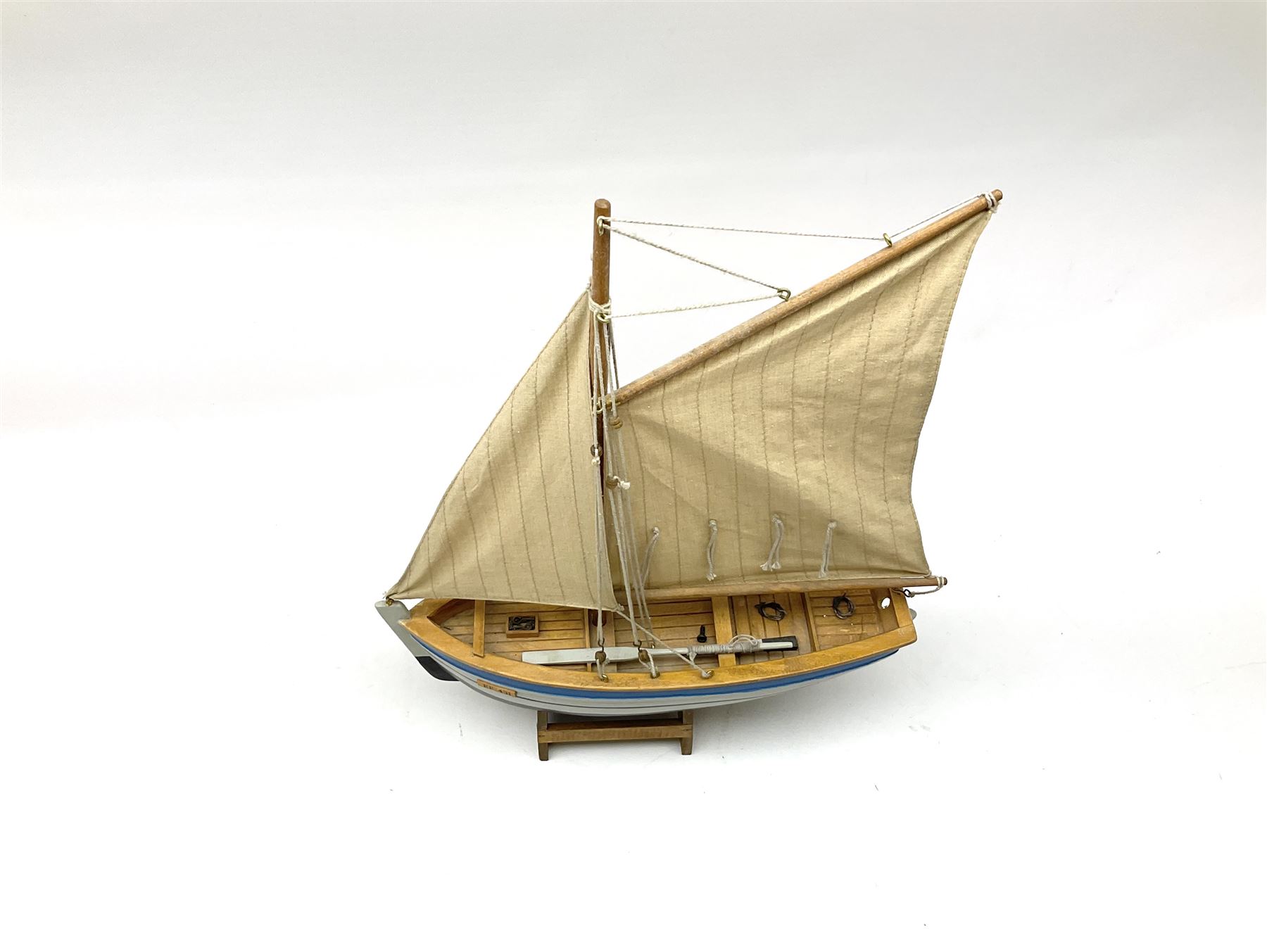 Wooden model of RMS Titanic, on a fixed black stand bearing plaque inscribed 'Titanic 1912', L54cm, H22cm, together with model of a sloop, gaff rigged on stand bearing plaque inscribed 'Sloop' L32cm, H42cm; and model of a fishing trawler on a stand bearing plaque inscribed 'Chalutier' L35cm, H28cm (3)