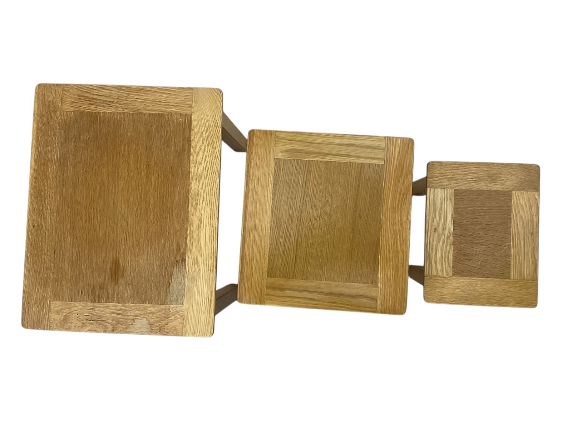 Contemporary light oak nest of three tables, each with rectangular top with moulded edge, raised on square supports