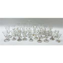 A large group of 18th and 19th century, and later in the style of drinking glasses, of various size and form, a number with engraved and etched decoration to bowls, and some with part fluted bowls.