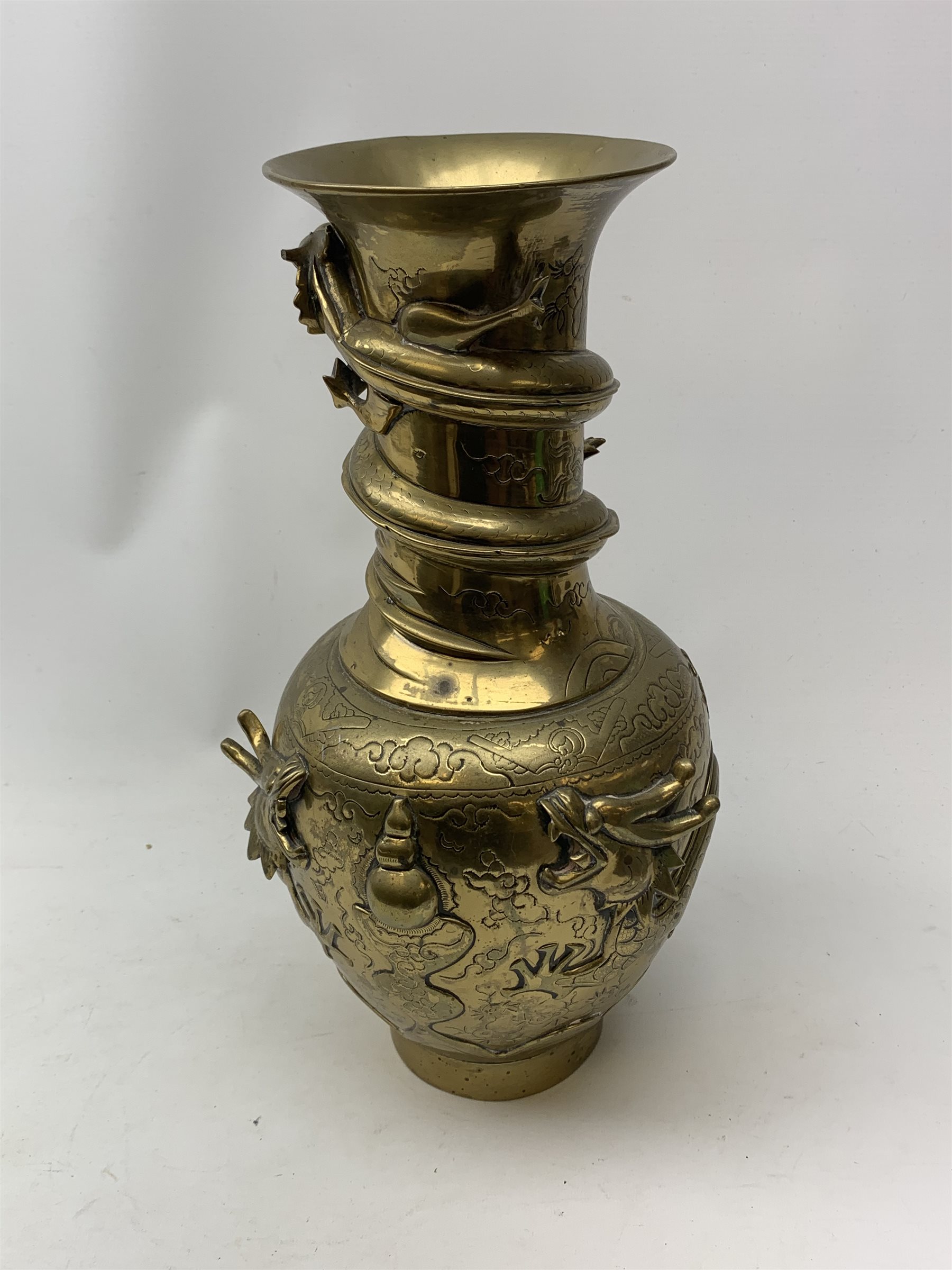 A large Chinese brass vase, of ovoid form with tall neck and flared rim, decorated in relief with dragons chasing a flaming pearl, and further incised with clouds and other detail, the base with relief dragon detail and character mark, H41