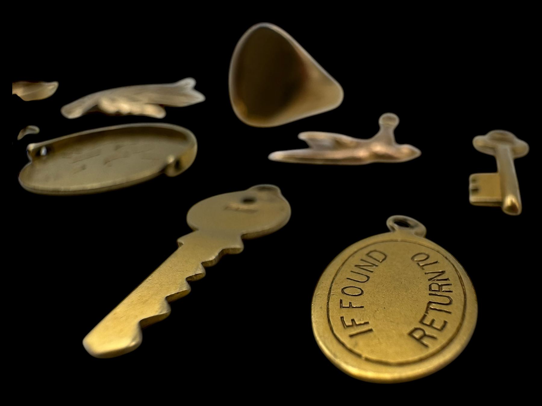 9ct gold charms, including crossed swords, signet ring, horseshoe and leaf, and a 14ct gold fireplace charm