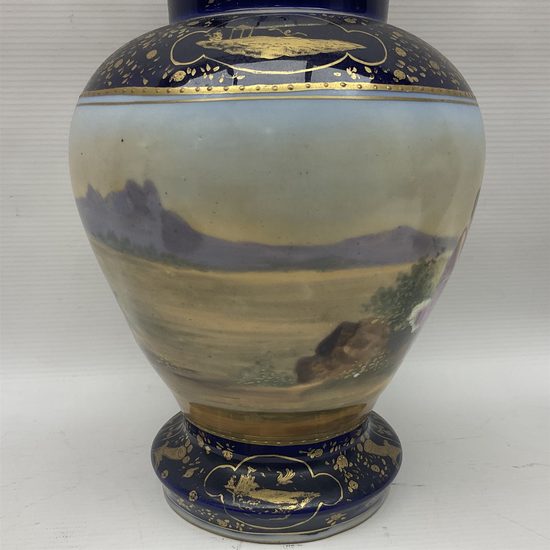 19th century Vienna style porcelain 'Musik' garniture, the central vase of baluster form with domed cover flanked by two smaller vases with twin curved gilt handles to short neck, each decorated with classical figural vignettes between blue borders heightened with gilt, H33.5cm