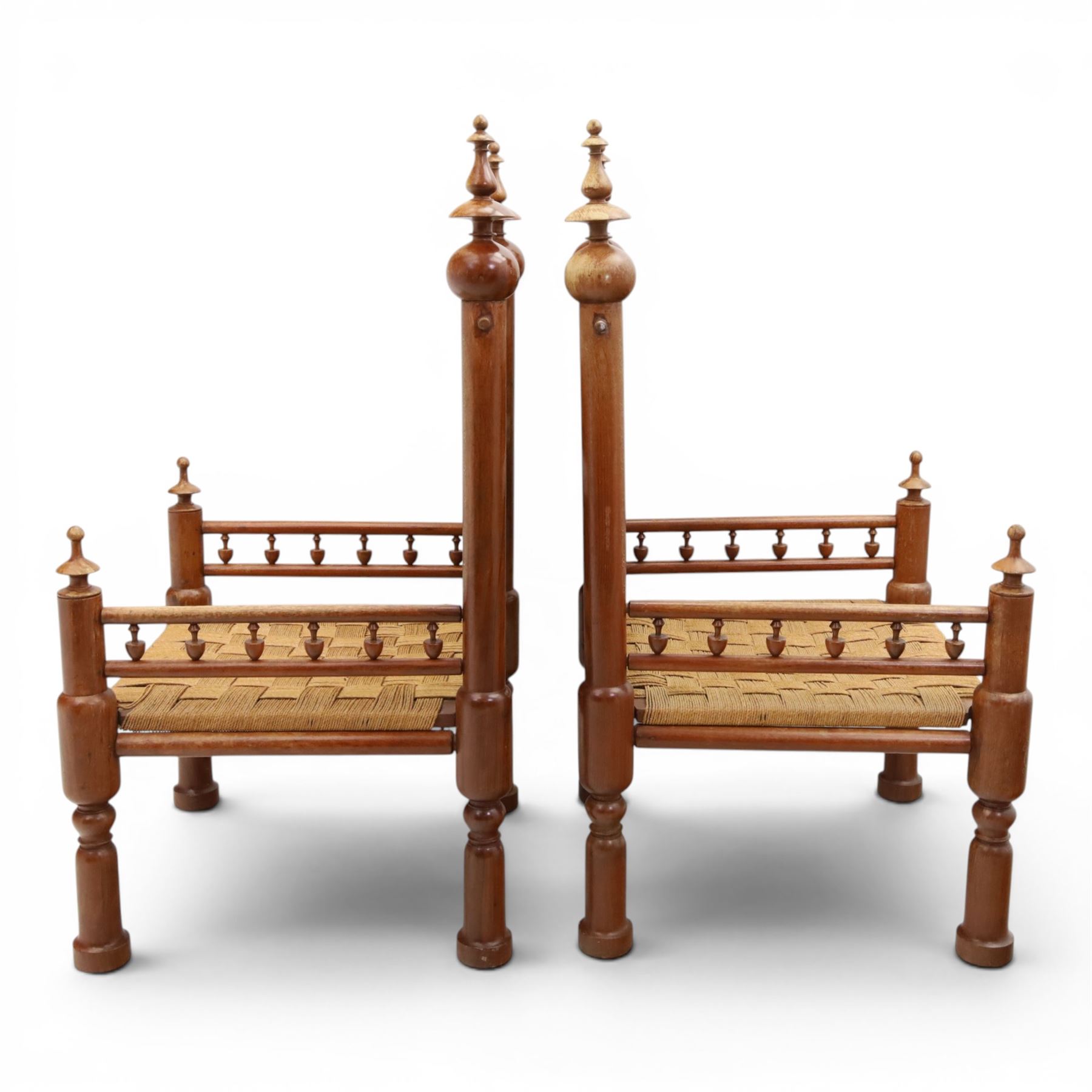 Pair of Anglo-Indian brass inlaid hardwood low chairs, the backs with turned spindle rails and rectangular panels inlaid with scrolling foliate decoration, woven rush seats within moulded frames, raised on turned supports with ring turned feet