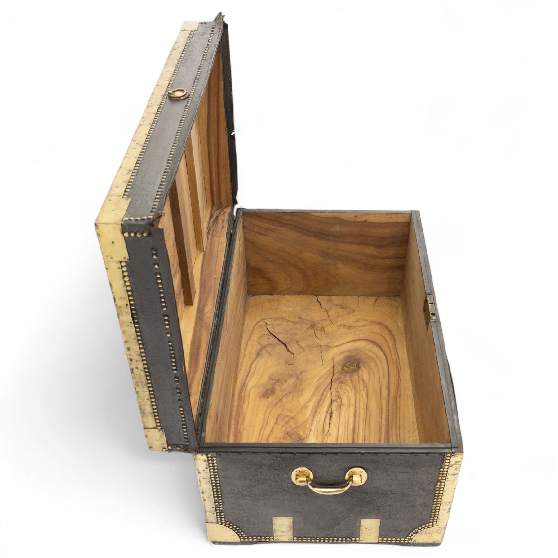 An early 19th-century Georgian brass-bound travelling trunk, leather-covered exterior with brass stud work decoration, front with central brass lock plate, hinged lid with camphor wood interior, external sides fitted with large brass carrying handles 