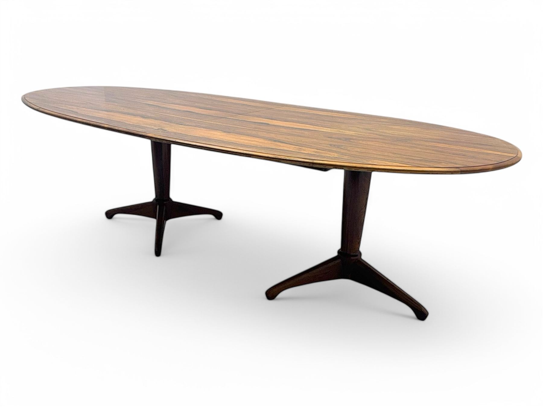 Andrew Milne for Heals - mid-20th century extending dining or boardroom table, oval top with one additional leaf, raised on twin tapering pedestal supports terminating in tripod feet