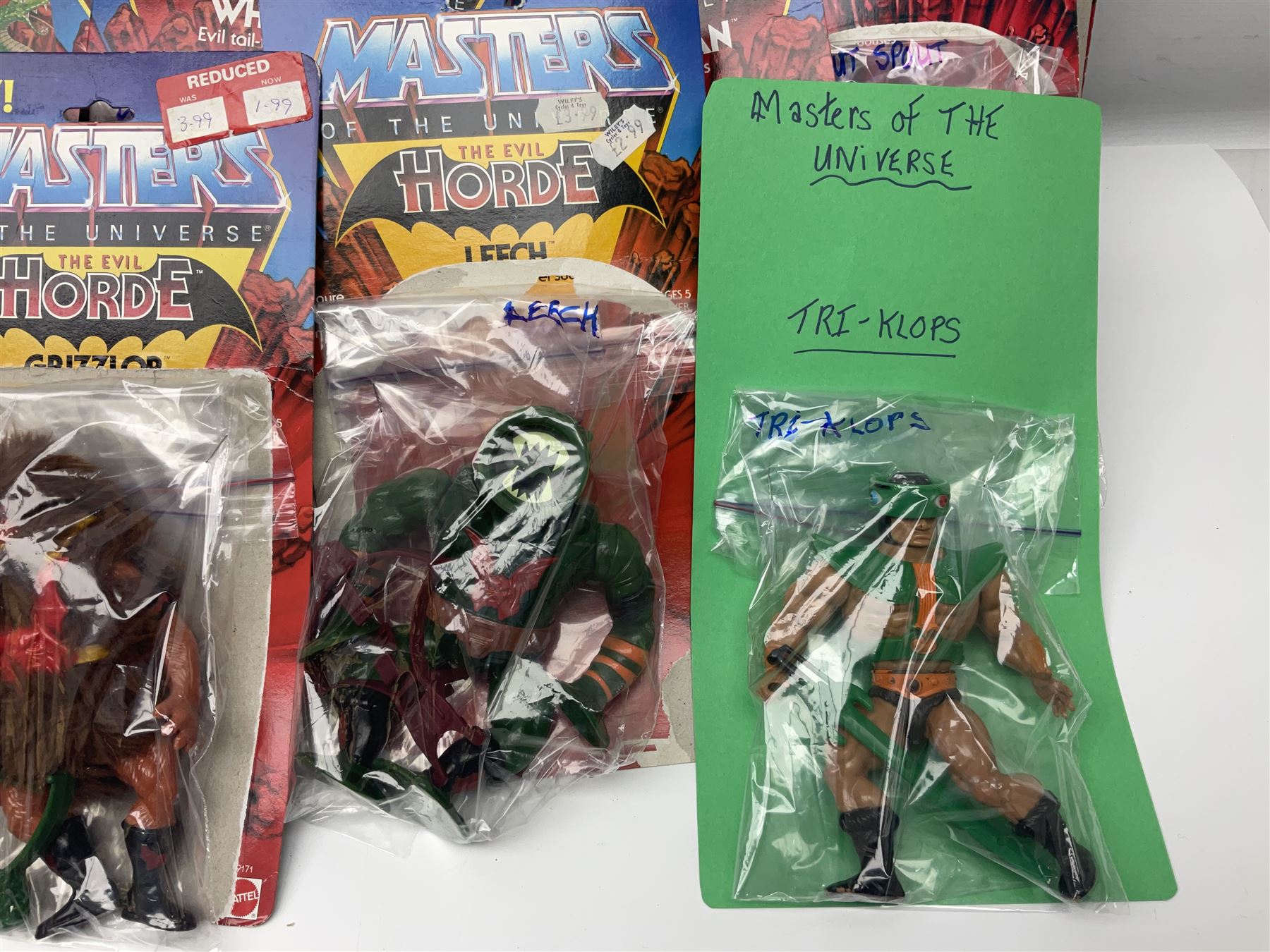 Thirty-one Masters of the Universe He-Man figures re-bagged on original backing cards;  two others lacking backing cards; boxed Modulok figure; bag of weapons and accessories; Roton, two horses and two battle cats; 1986 & 1987 Annuals; Ladybird and other story books; Panini sticker album; instructions etc