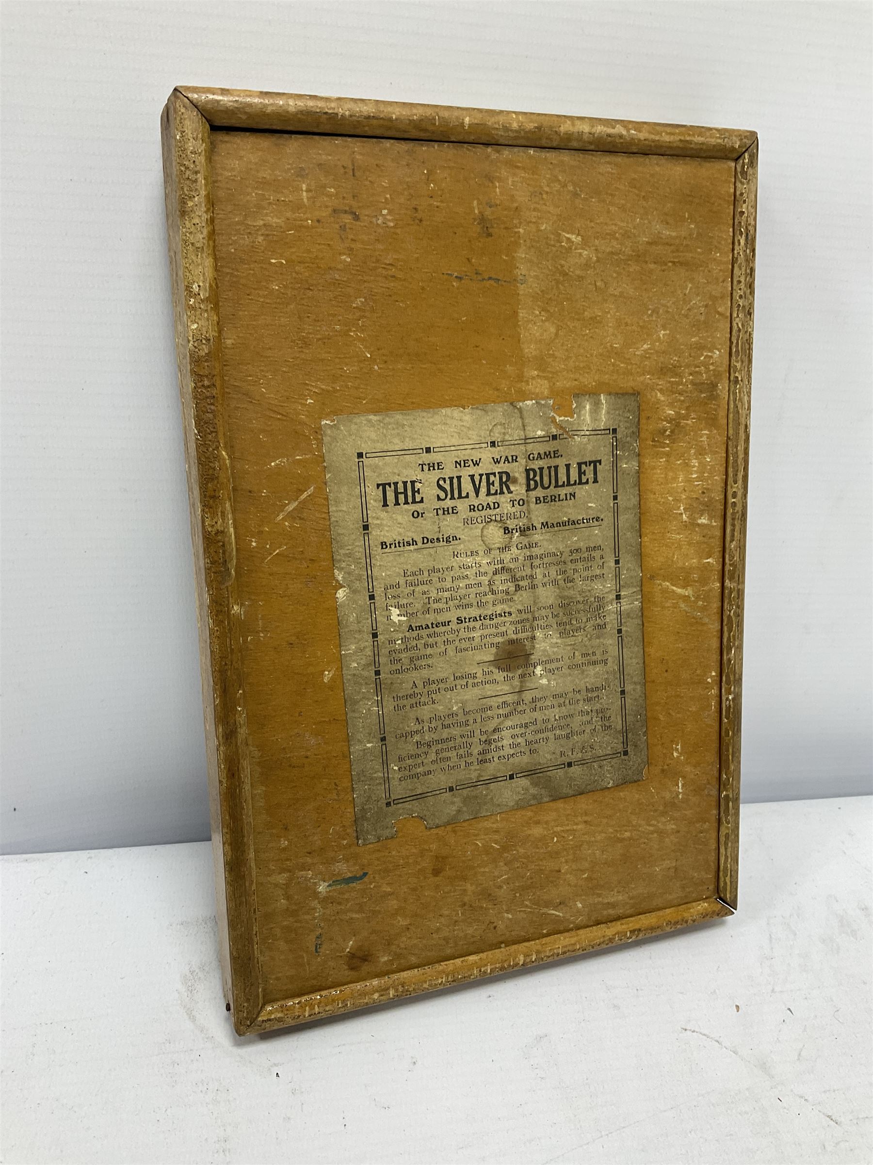 WWI 'The Silver Bullet or the Road to Berlin' ball bearing puzzle game, the stylised printed card map marked with various German towns and hazards on the allied advance to Berlin passing through towns and cities such as Hamburg and Dresden, manufactured by R. Farmer and Son circa 1916, with instructions label verso, in glazed frame