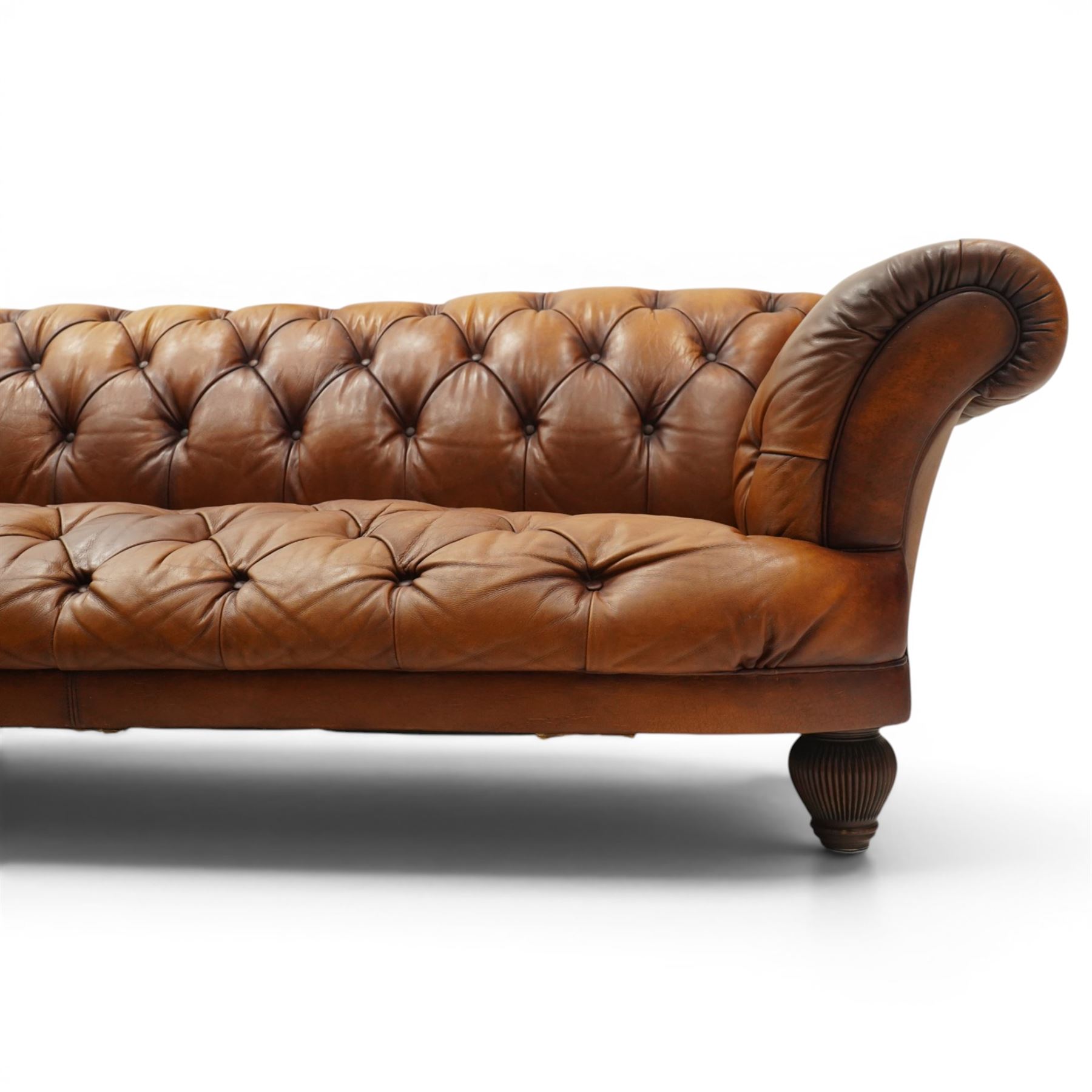 Tetrad - 'Oskar' grande three-seat sofa, Chesterfield shape with rolled arms over serpentine back and front, upholstered in fully buttoned tan leather, raised on reed-moulded feet of globular form