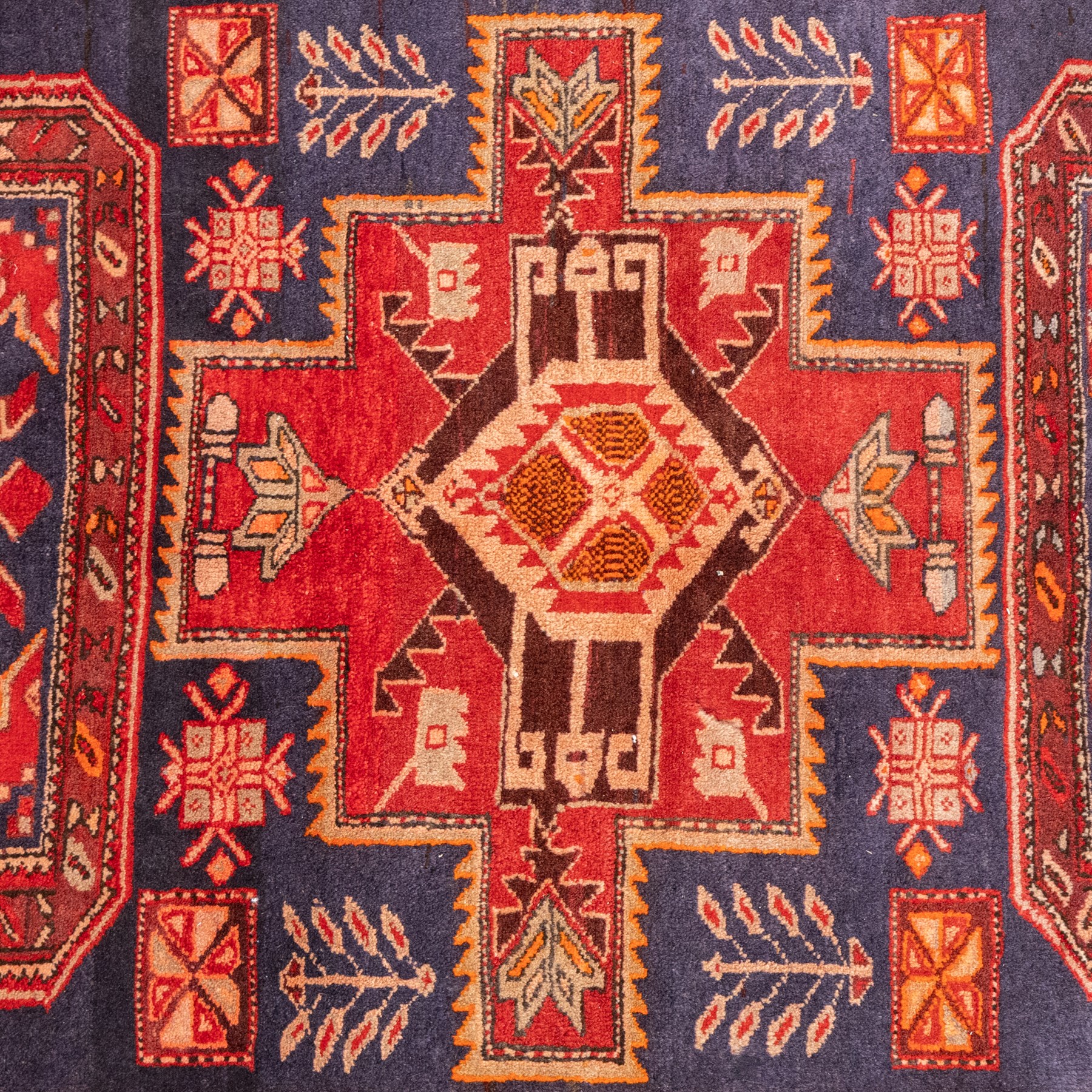 North West Persian runner, the indigo field decorated with three stepped cruciform medallions alternating with two octagonal panels, interspersed with stylised flowerheads and foliage, enclosed by an ivory ground floral border and red guard bands