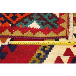Persian Qashqai crimson ground rug, the central narrow ivory field decorated with repeating hooked geometric lozenges in multicolours, with a densely decorated guard band
