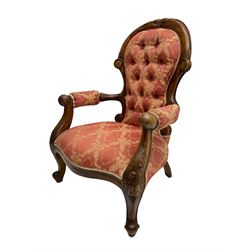 Victorian walnut framed armchair, cresting rail carved with scrolling foliate decoration, scrolled arm terminals over cabriole supports, upholstered in buttoned coral and ivory Damask fabric with overstuffed seat
