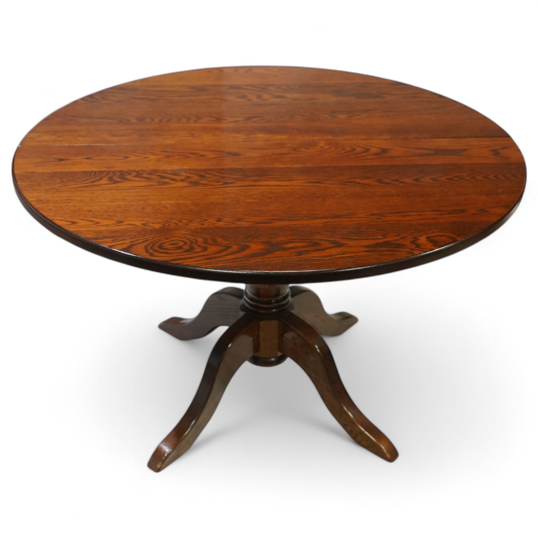 Late 20th century oak extending dining table, circular top with moulded edge, centre split revealing an additional leaf, on turned column support with four downswept legs (Extends to 165cm)