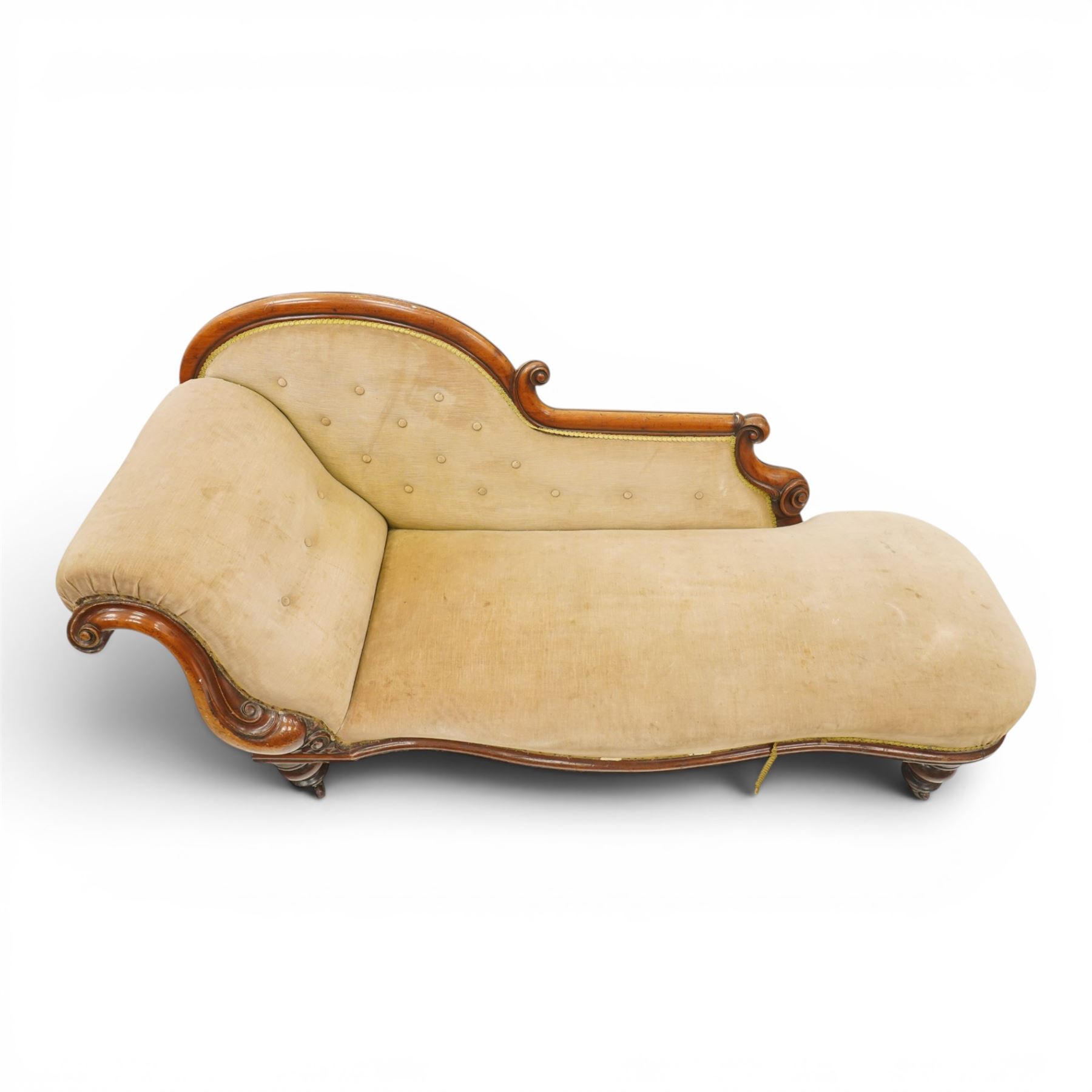 Victorian mahogany framed chaise longue, shaped button upholstered back with scroll-over end, padded seat and arm, moulded frame with carved scroll decoration, on turned supports with brass castors