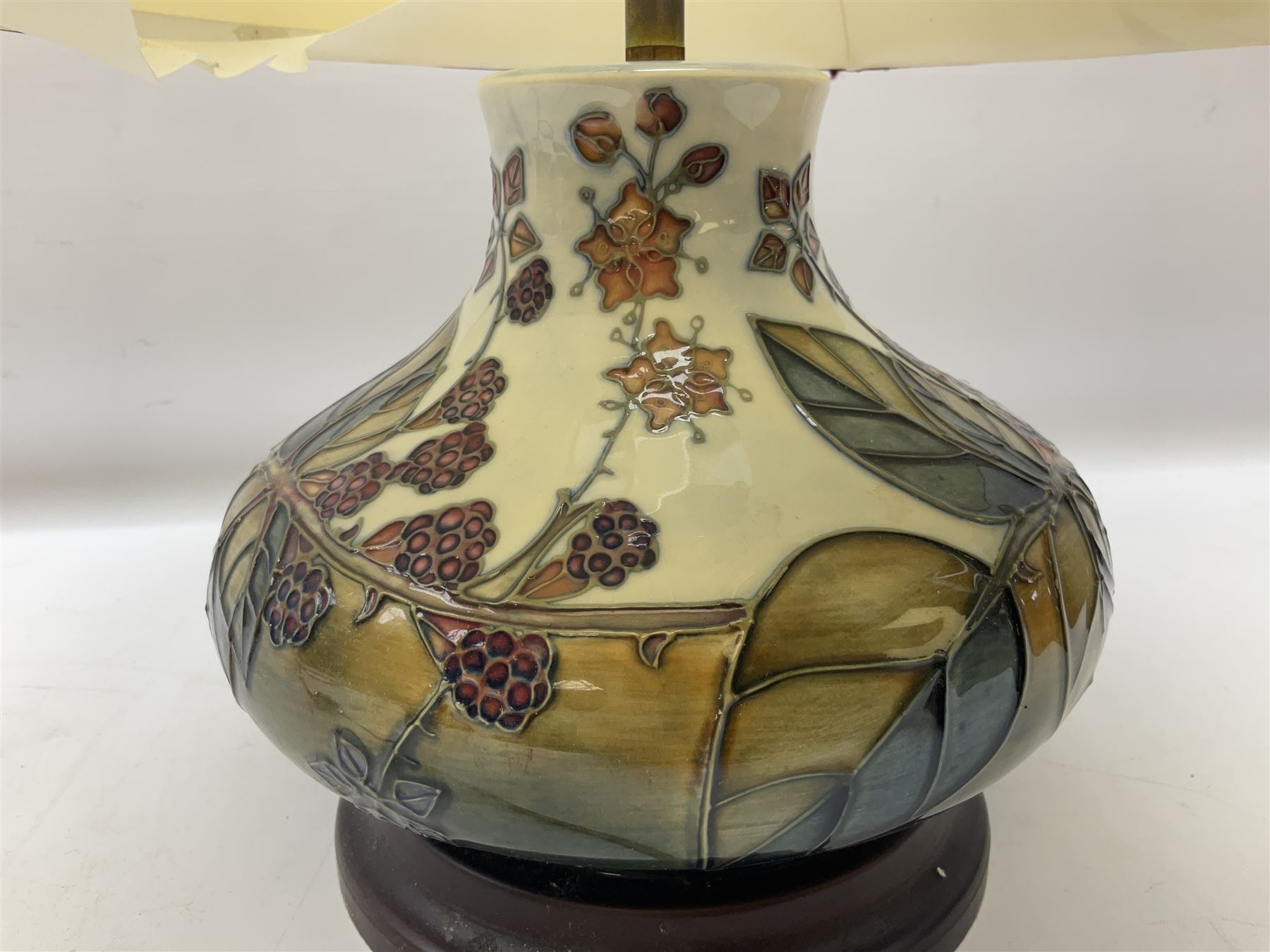 Moorcroft table lamp of squat baluster form, decorated in the Autumn Blackberry, with Moorcroft cream fabric shade with gold, green and red piping, overall H38cm