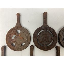 Seven late 20th century cast iron trivets, to include two Queen Elizabeth Silver Jubilee examples, L21cm