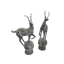 Pair of cast iron garden stag finials atop a sphere base, in rustic finish