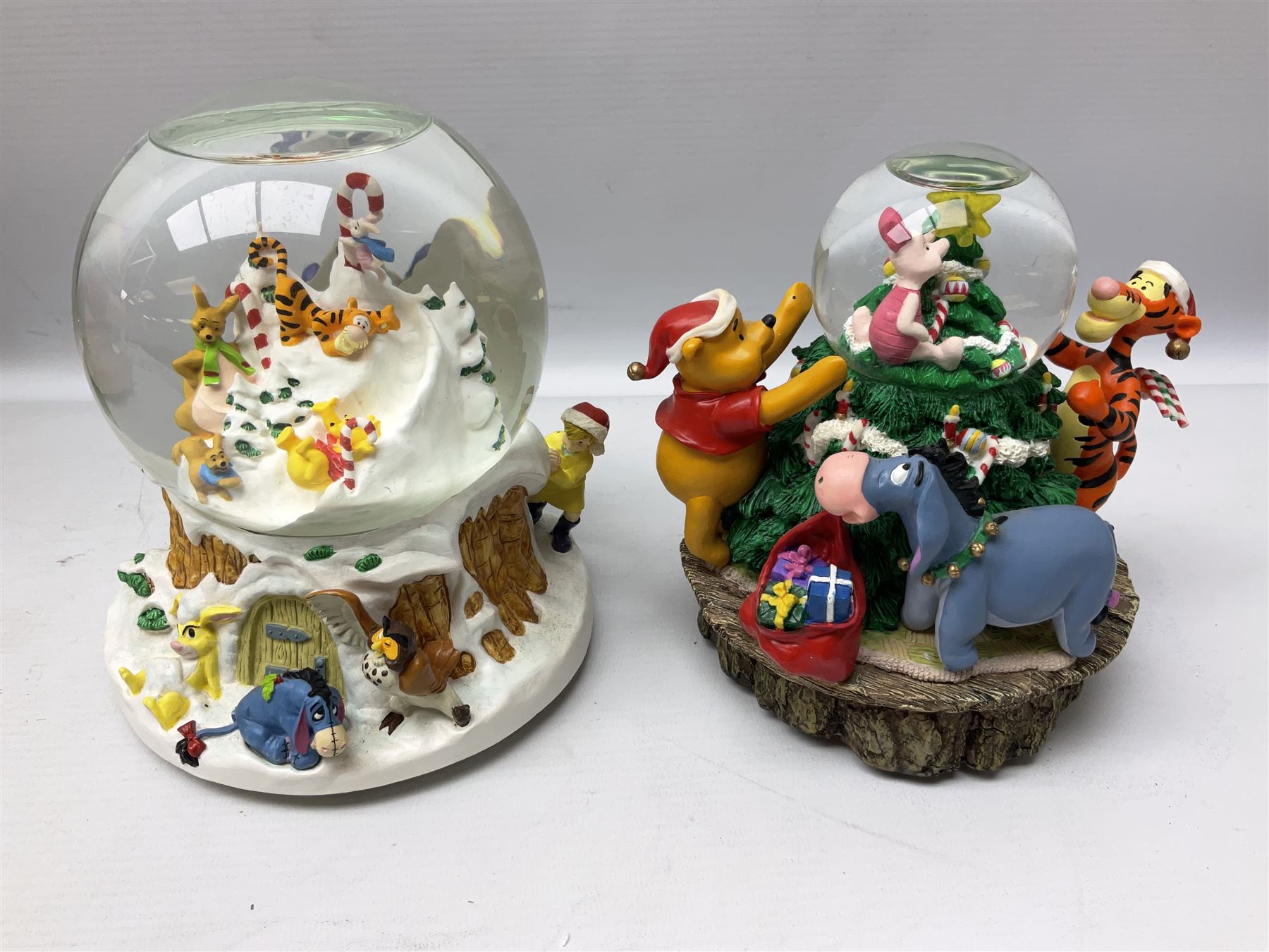 Six Disney Winnie the Pooh Christmas snow globes, comprising large Mr Christmas Holiday Snowfall, An Enchanted Christmas, It's A Small World Christmas 1994,  Tree Trimming, 1995 Christmas At Our House and Christmas Band Concert, together with Mr Christmas Holiday Go Round, all with boxes (7)