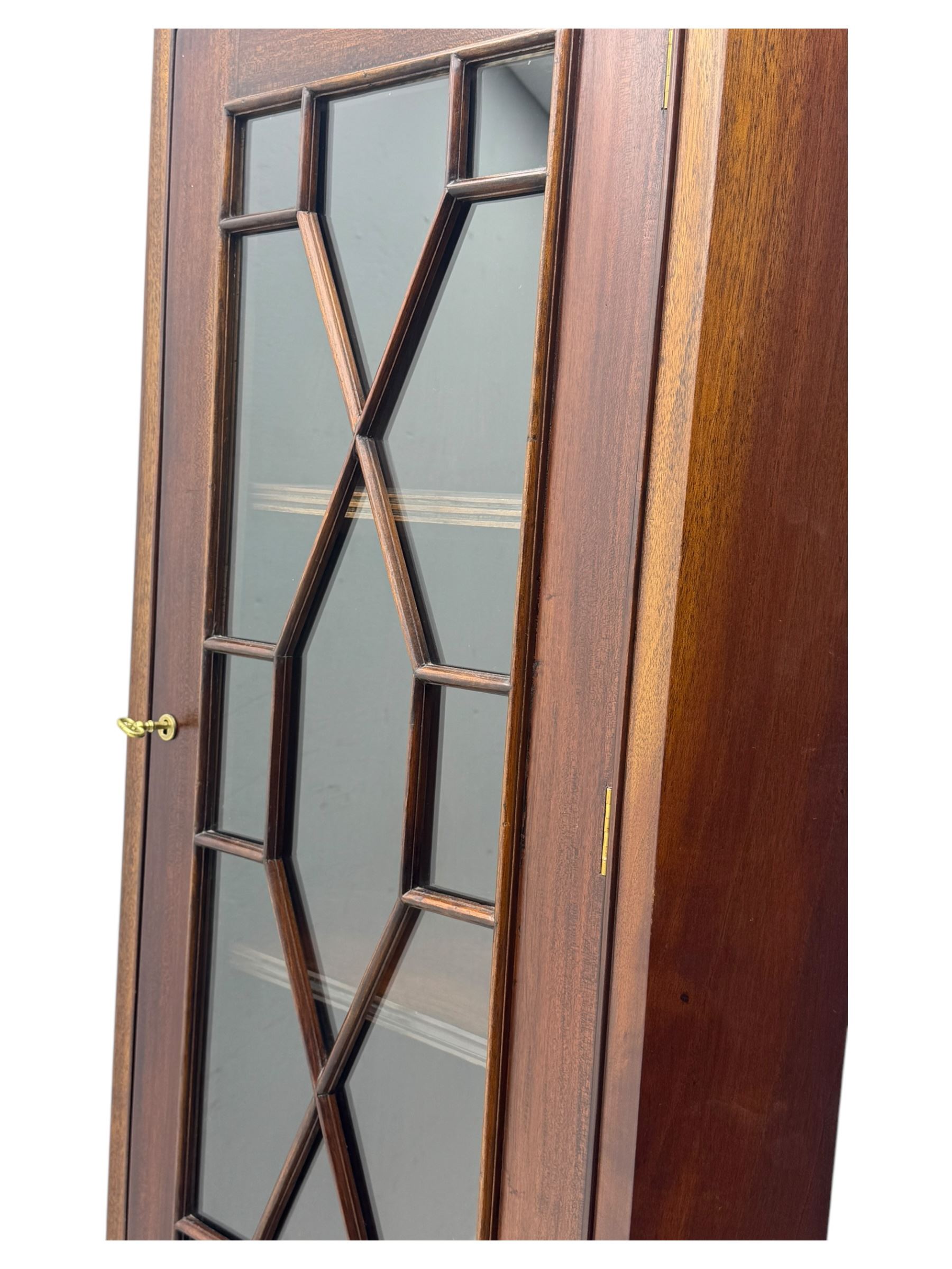 Late 20th century mahogany corner cabinet, dentil moulded cornice above a glazed door with astragal glazing enclosing two shelves, lower cupboard with fielded panel door and turned shell motif, on plinth base