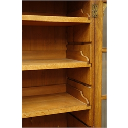  Edwardian oak bookcase with stepped cornice and six sliding shelves, enclosed by two glazed doors on skirted base, W127cm, H176cm, D34cm  
