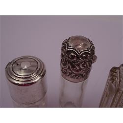 Four silver mounted glass scent bottles, including a Victorian cut glass example with embossed silver cover, and three cylindrical plain glass examples, on with engine turned decoration, three with glass stoppers, together with a pair of silver salts and spoons, all hallmarked, tallest H8cm