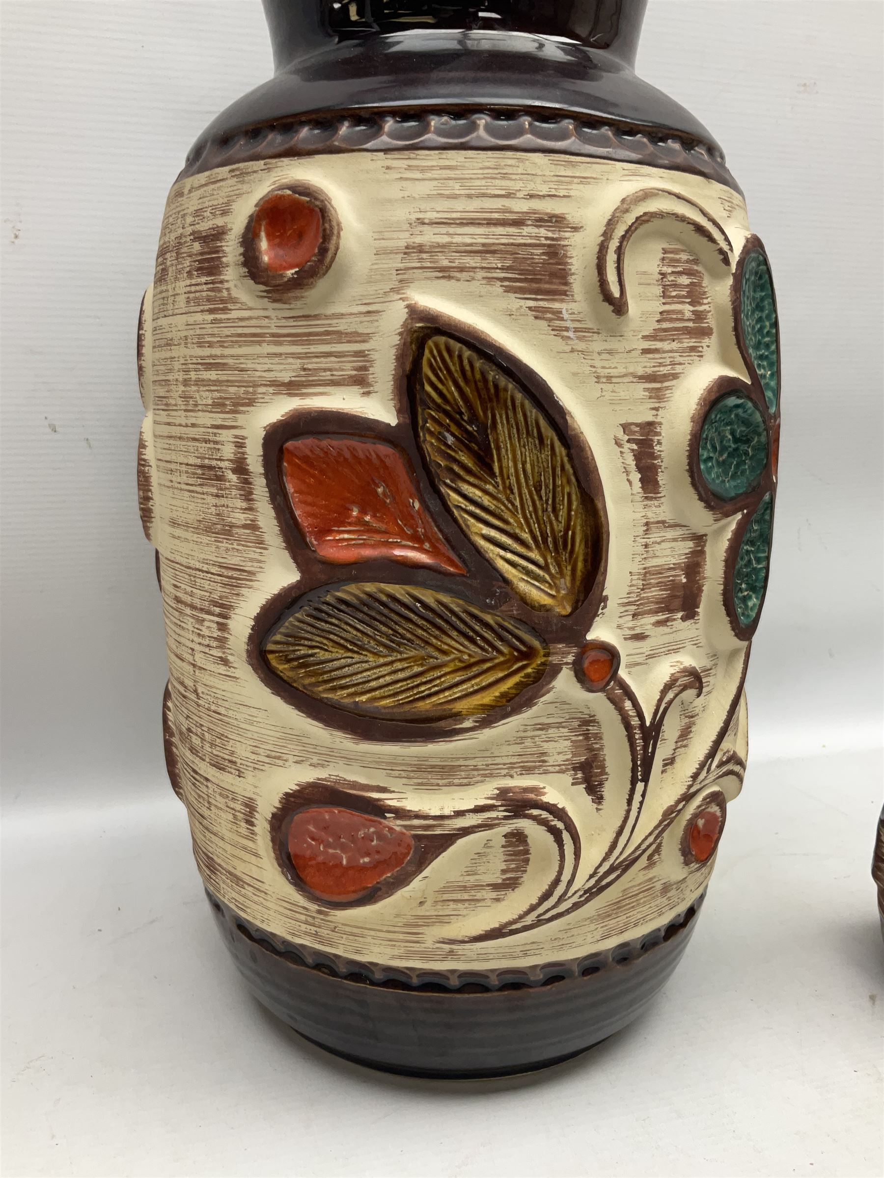 Pair of Bay West German vases, with bold moulded flower and foliage decoration in green, orange and ochre on brown ground, largest H40cm