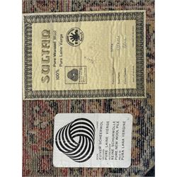 Belgian Sultan woollen ground rug, central navy field densely decorated with floral sprays and geometric patterns (192cm x 135cm); handwoven tribal terracotta ground rug (121cm x 71cm); Persian crimson ground runner, all over stylised floral and foliate motifs (266cm x 94cm)