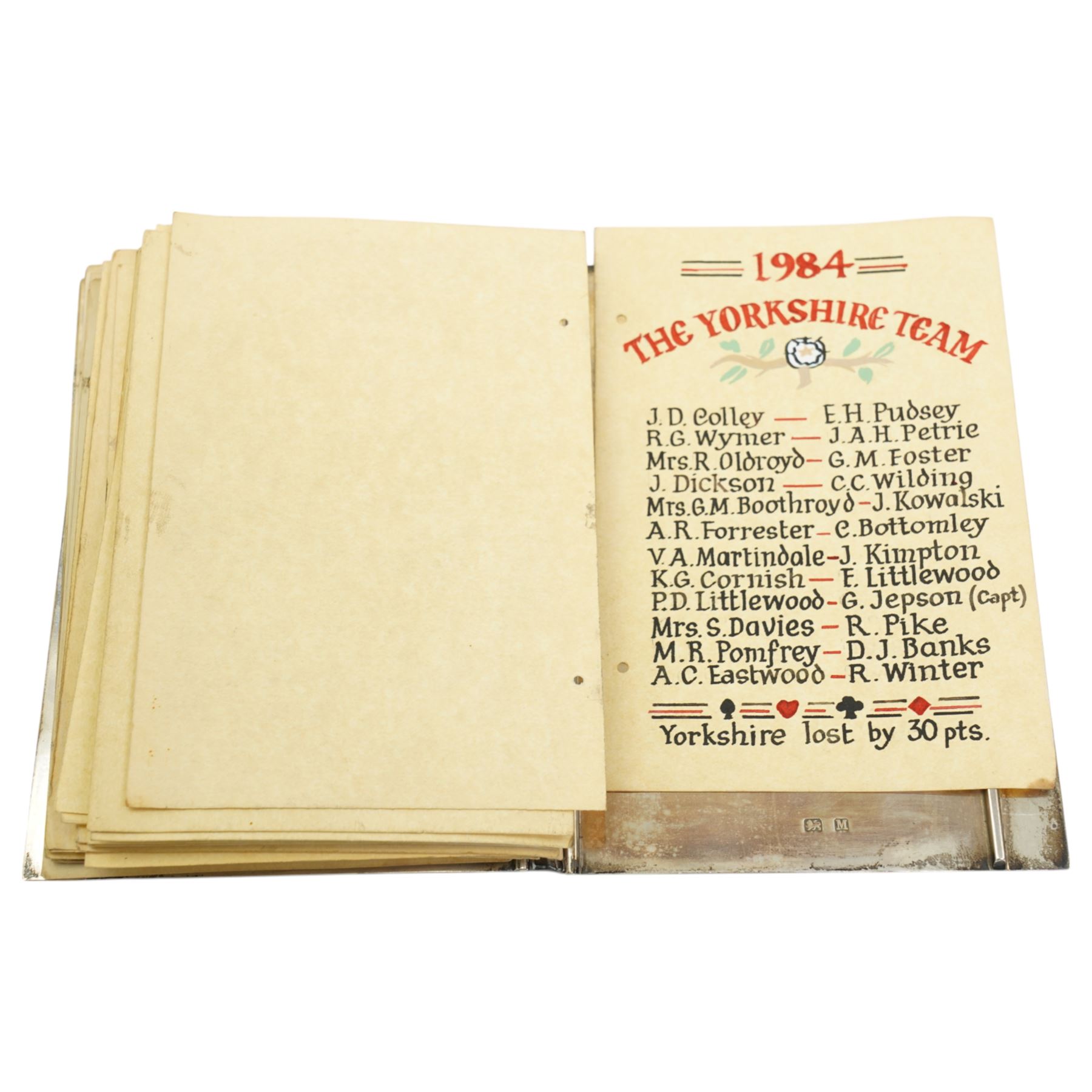 'The Roses County Contract Bridge Match, Yorkshire V Lancashire presented by Capt. G Fell 1936 for a record of the teams' - A silver booklet decorated with enamel roses containing hand drawn lists of the teams 1936 together with other team lists 1955-1984 15cm x 10cm Birmingham 1936 Maker S Blackensee & Son Ltd