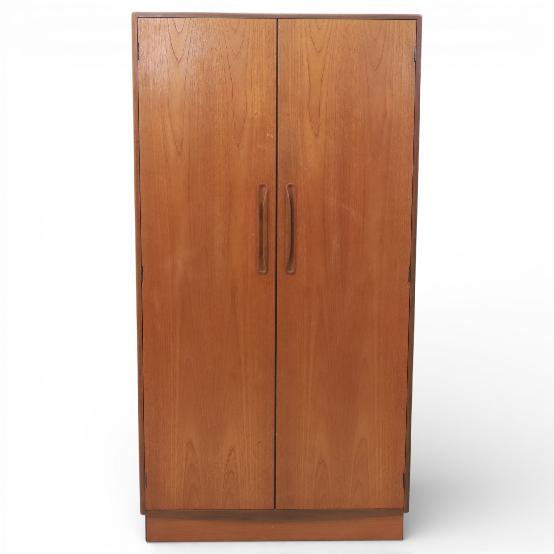 G Plan - 'Fresco' teak double wardrobe, twin doors enclosing a single clothes rail, on a recessed plinth base with castors beneath  