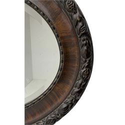 Early 20th century oval mirror, moulded frame decorated with trailing foliage and berries, bevelled plate