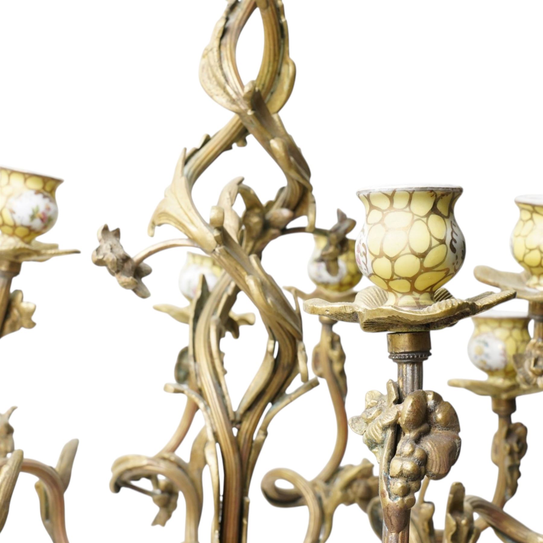 Rococo design brass ten light chandelier with scroll branches and ceramic candle holders H74cm