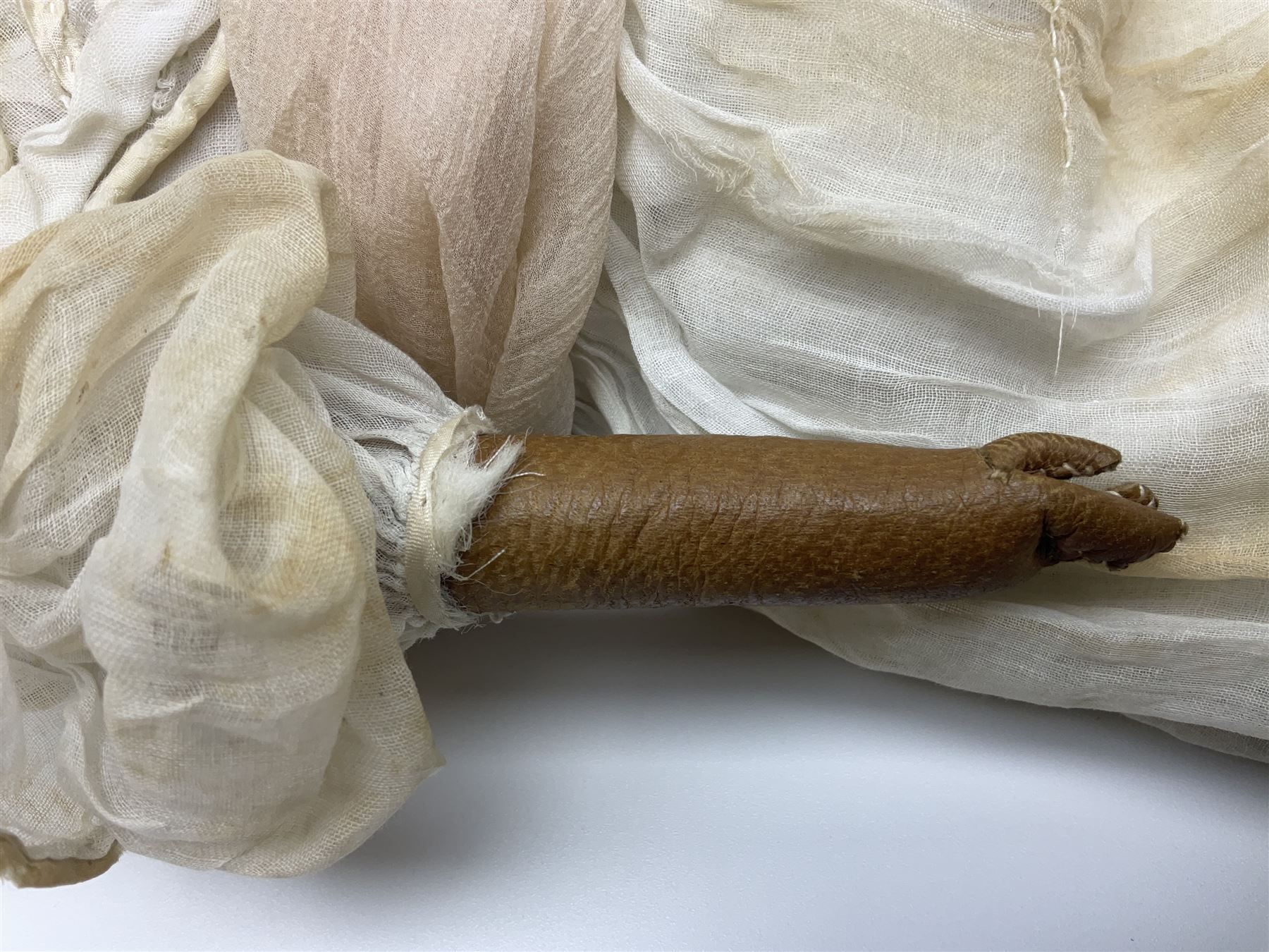 Victorian wax shoulder head doll with pale complexion, applied hair, inset glass eyes and fabric covered jointed body with kid leather lower arms; white linen dress and undergarments H50cm