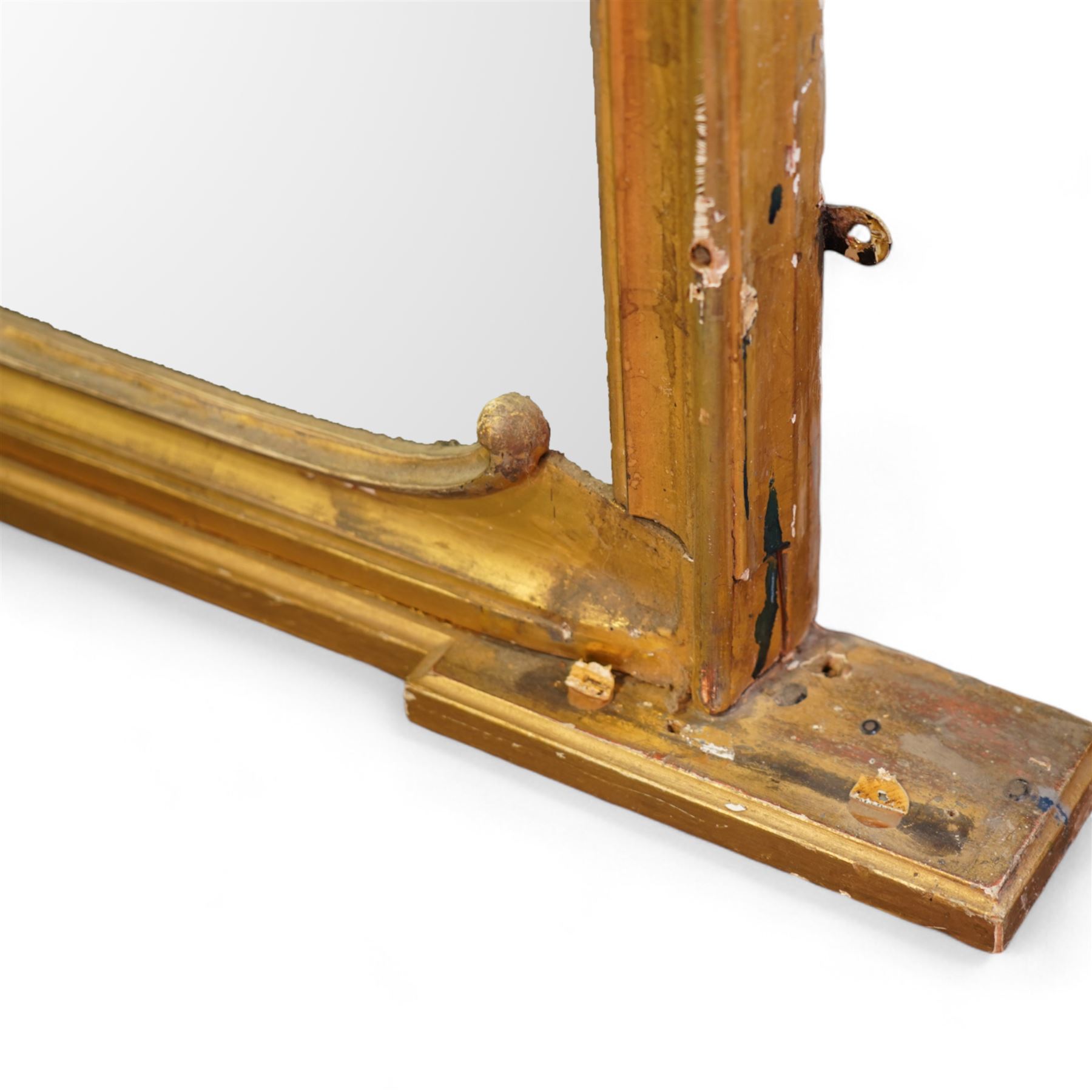 Large Victorian gilt wood overmantle mirror, shaped cresting rail with curled acanthus leaf pediment, the corners decorated with foliate C-scrolls and flower heads, curled foliage lower corner brackets, plain mirror plate 