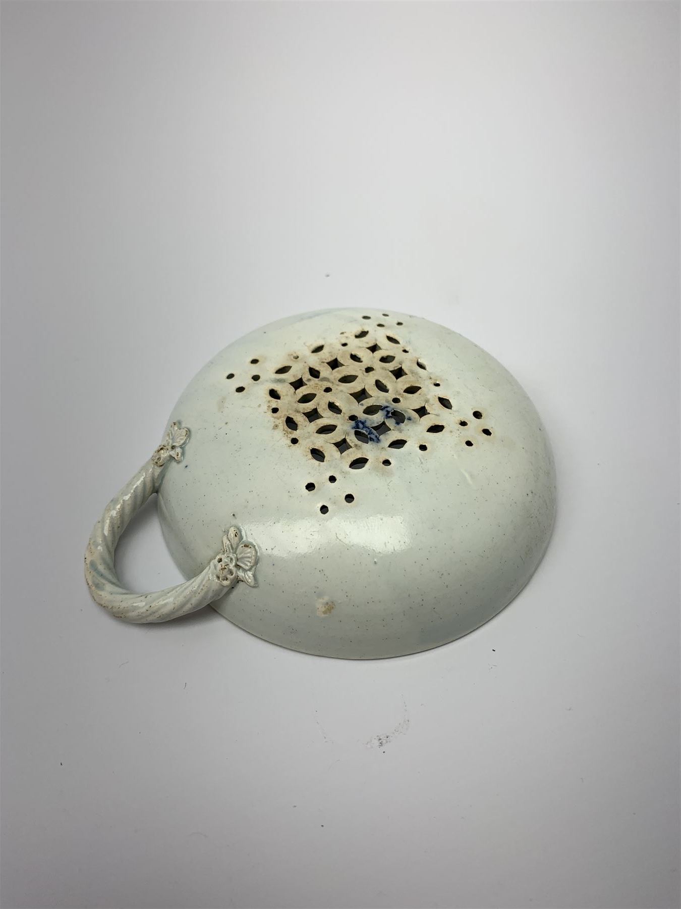 Late 18th/early 19th century Leeds Pottery egg drainer, the pierced bowl of circular form decorated with blue transfer printed floral spray and floral border, the twisted handle with foliate mounts, bowl D9cm