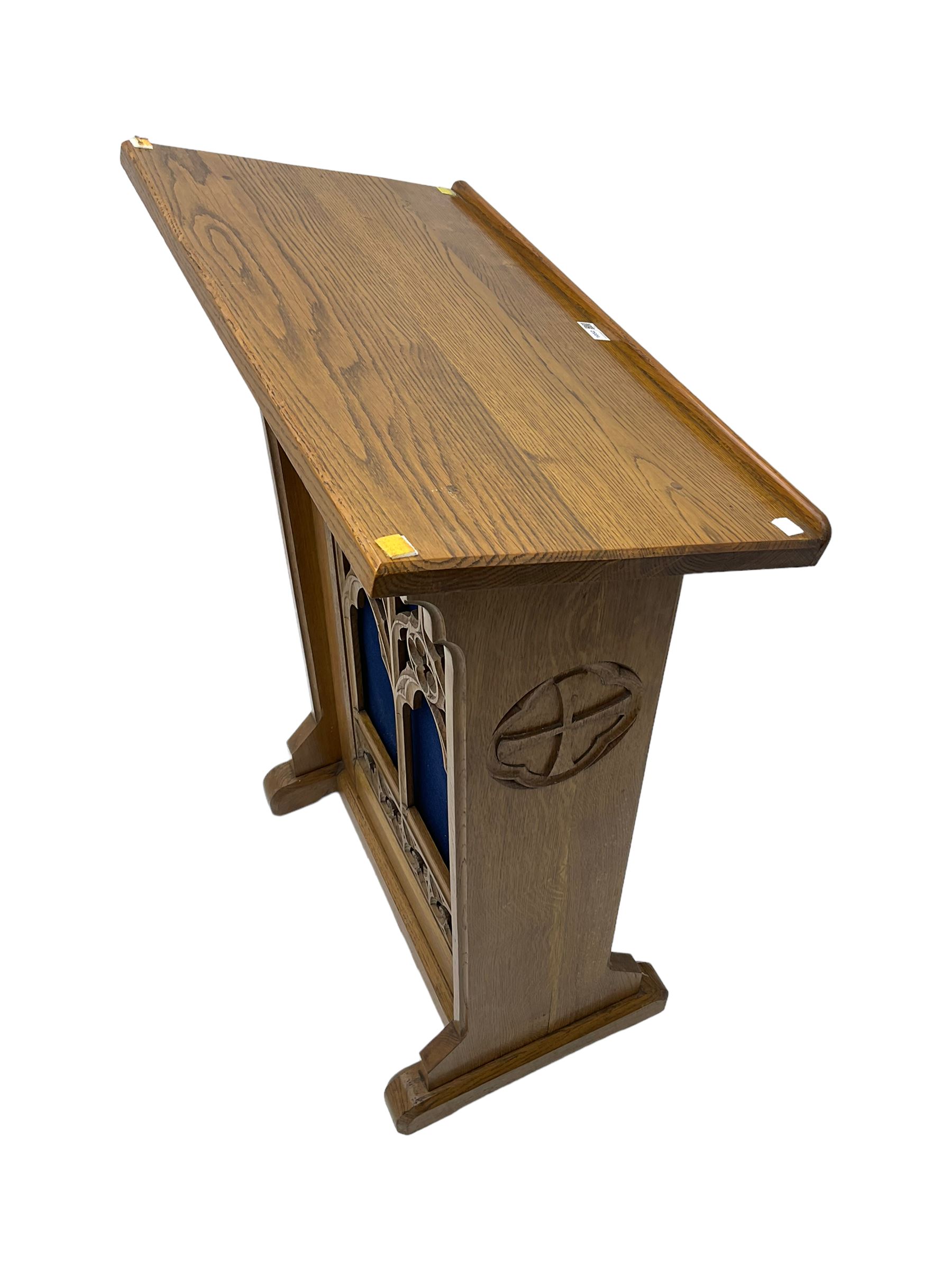 20th century ecclesiastical oak lectern, the sloped rest on moulded end supports with carved decoration, the front panelled with Gothic style carved and pierced tracery, on sledge feet
