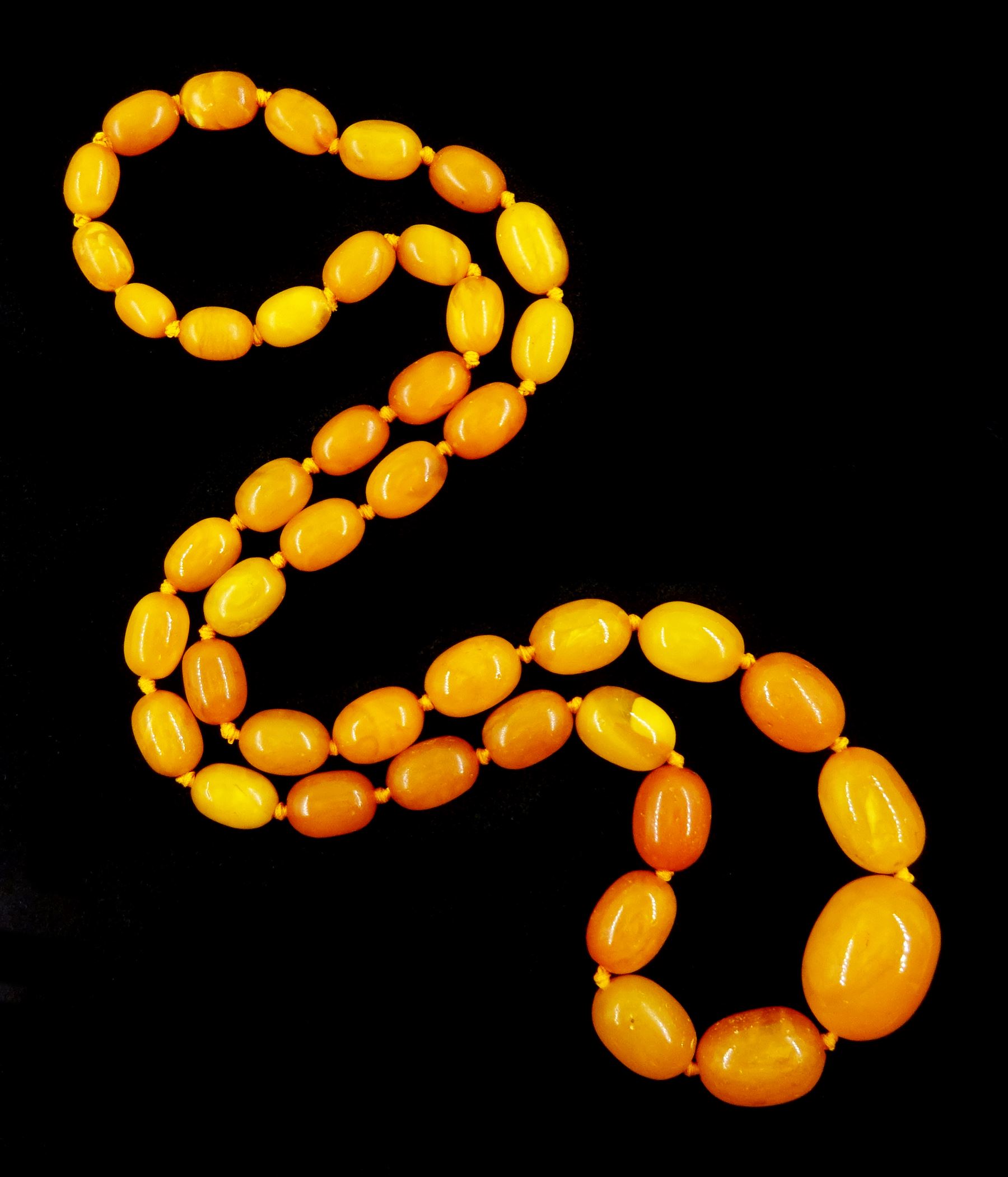 Single strand graduating oval butterscotch amber bead necklace, with three additional loose amber beads