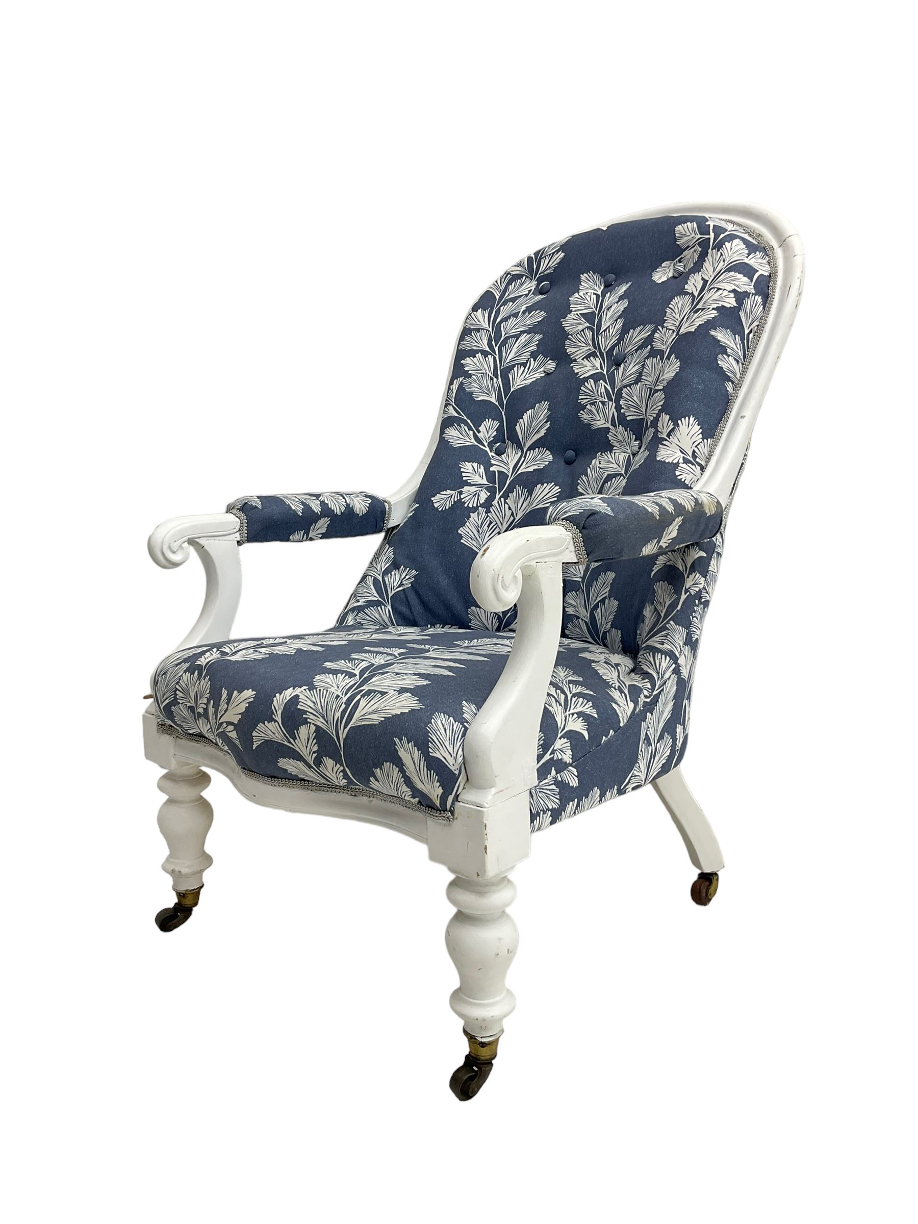 Victorian white painted open armchair, upholstered in blue fabric decorated with trailing leaf pattern, scrolled arm terminals on turned front supports with castors