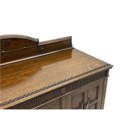 Early 20th century oak sideboard, raised stepped arch back over moulded rectangular top, fitted with two drawers and two panelled cupboards with geometric mouldings, on turned and lobe carved baluster feet united by stretchers 
