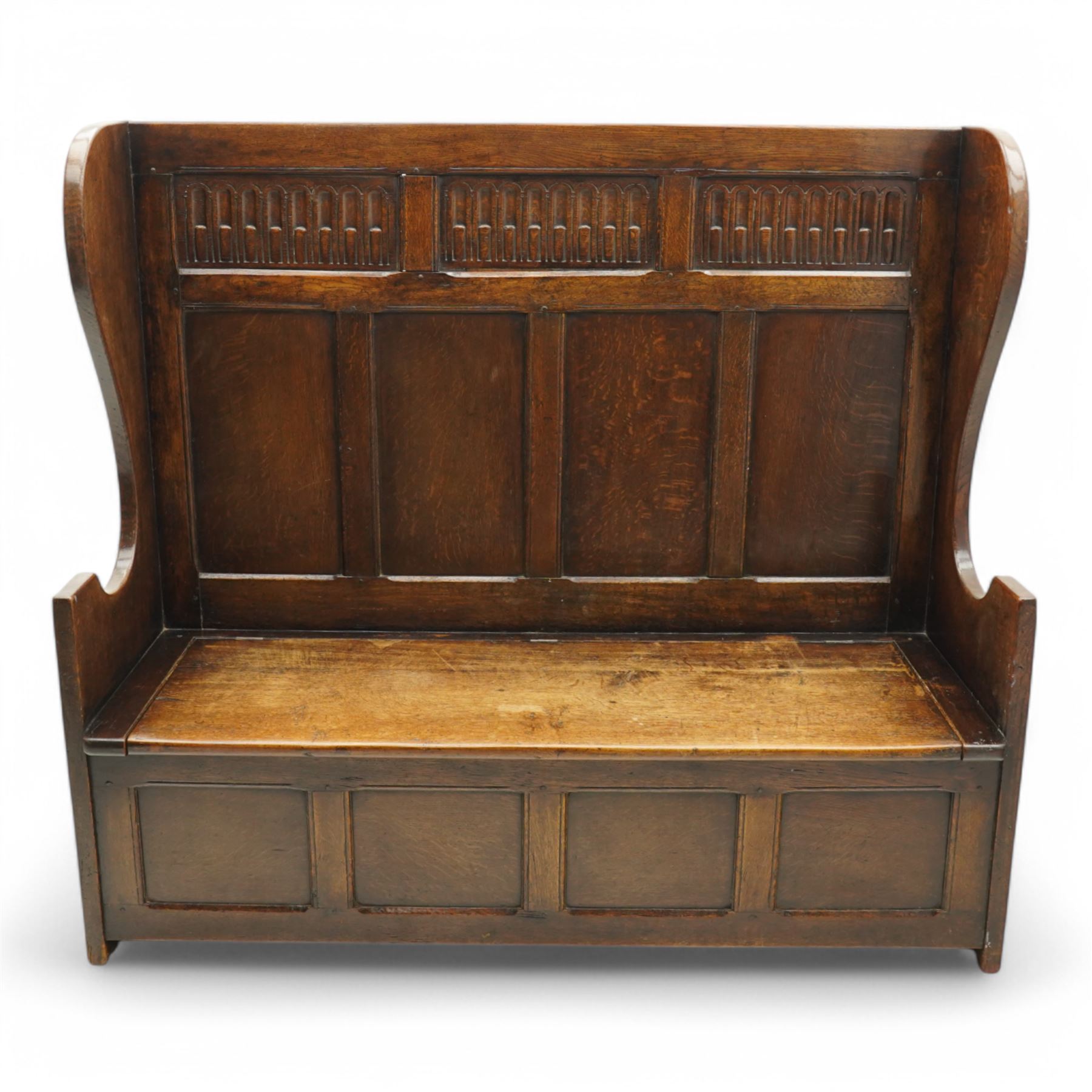18th century design oak hall bench or settle, tall panelled back decorated with carved arcade, on two shaped end supports, hinged box seat opening to reveal a storage compartment, on a panelled base