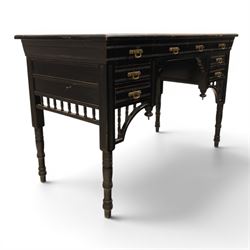 Victorian Aesthetic Movement ebonised writing desk, rectangular top with inset tooled leather, central frieze drawer with pierced spandrels, flanked by two banks of three drawers, brass swing handles, raised on turned supports 