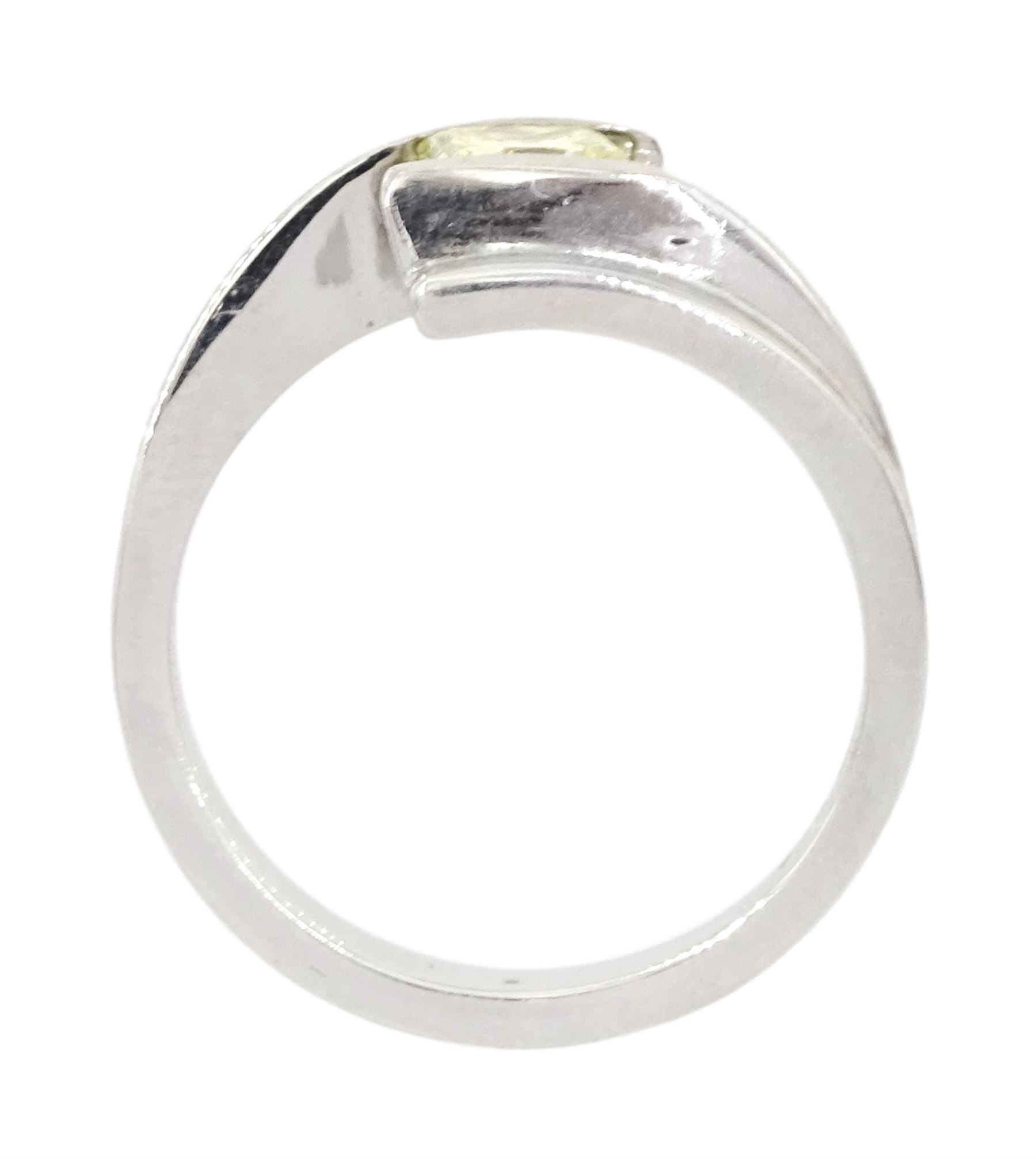 Platinum diamond ring, tension set with a single princess cut fancy yellow diamond of approx 0.60 carat, hallmarked