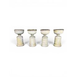 Four 20th century good quality weathered cast stone pedestal urns, circular lobed bowls with rope twist and lattice border, raised on squat base with fluted columns