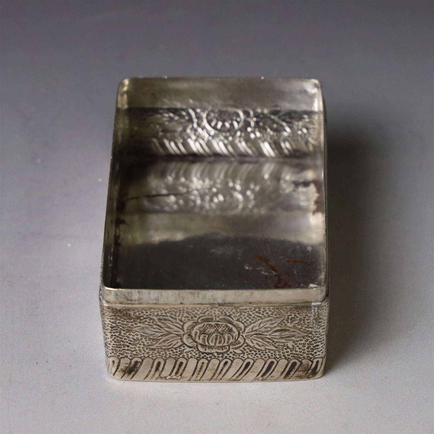 19th century Continental silver box, of rectangular form, the lift off cover with repousse figural scene, the base chased with vacant panels, acanthus scrolls and flower heads, unmarked, H4.5cm W8.5cm D5.5cm