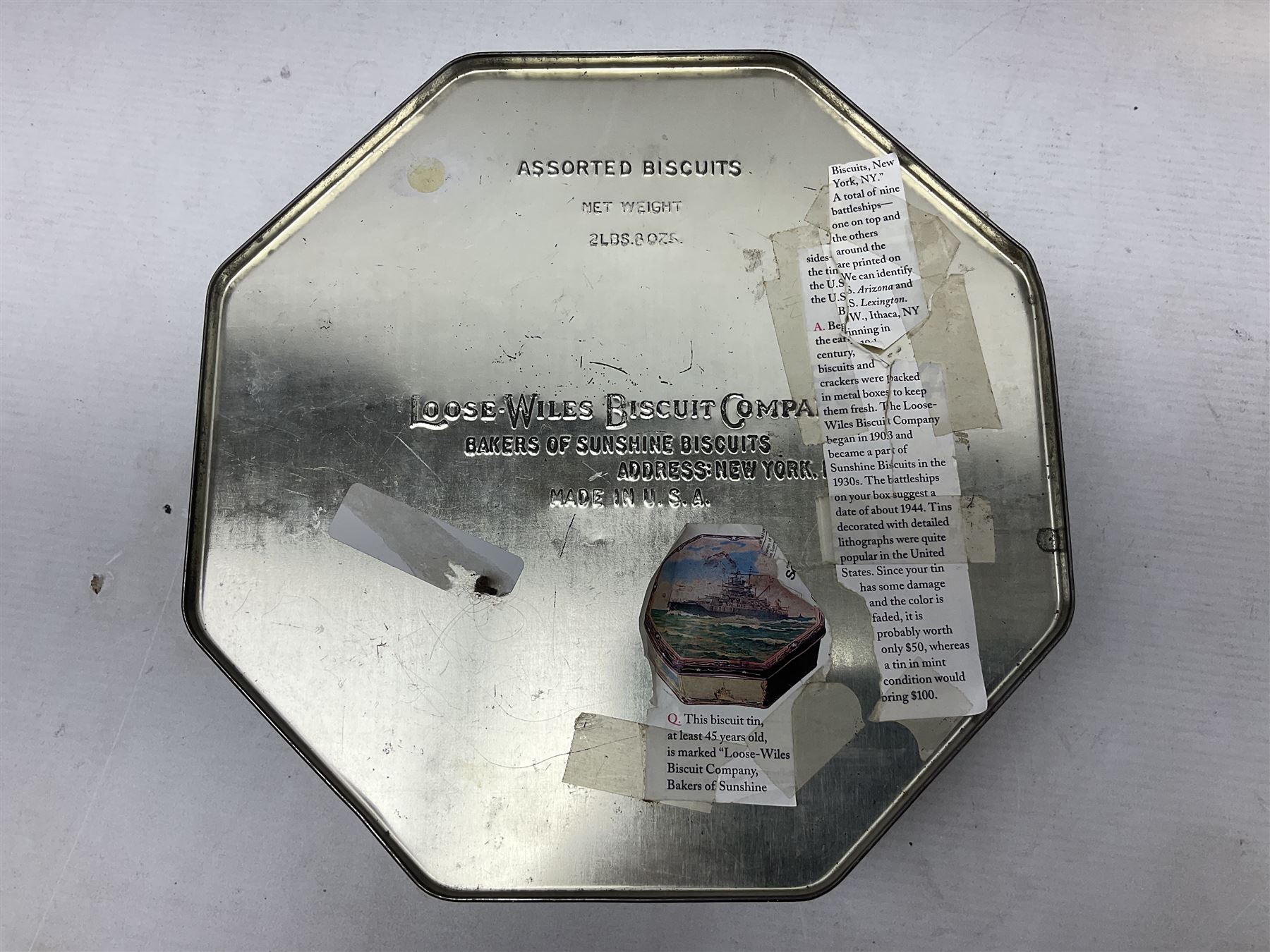 WWII period US Navy Mark I deck clock, the black circular dial with Arabic numerals,  luminous dot markers and subsidiary seconds dial marked 'Mark I Deck Clock U.S. Navy 15211 1941', in bronze bulk head case D20cm; and a Loose-Wiles Biscuit Company octagonal tin decorated with nine different US Warships (2)