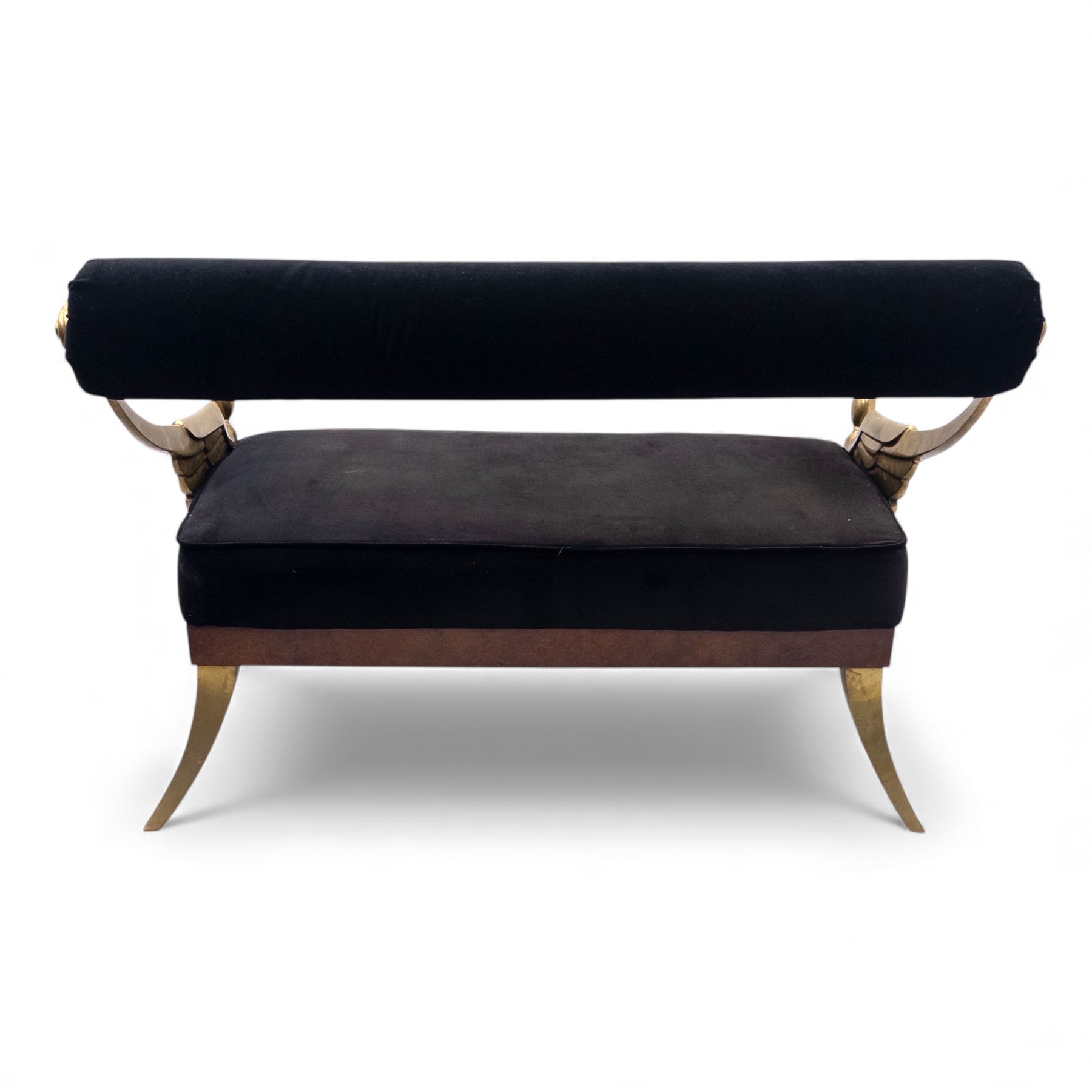 Late 20th century pair of Empire inspired brass metal framed two-seater sofas, upholstered in black velvet with cylindrical backrest and sphinx form arms terminating in paw feet, together with matching deep buttoned black velvet footstool on brass capped legs (Footstool H 38cm, W 70cm, D 70cm)