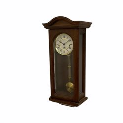 A 20th century  Westminster chime, spring driven three train “William Widdop” wall clock with a visible gridiron pendulum, chiming the hours and quarters on horizontal gong rods, white two-piece dial with roman numerals and minute track, steel spade hands, wooden case with full length glazed door and curved pediment with moulded cornice.
With key.
 
With a 20th century Westminster chime three train mantle clock with Hermle (German)  balance wheel movement chiming on four gong rods, ornate dial with Arabic numerals and minute track, contrasting black pierced steel hands, strike/silent lever.
H23cm W35cm D15cm