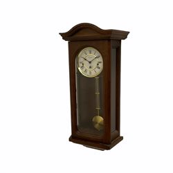 A 20th century  Westminster chime, spring driven three train “William Widdop” wall clock with a visible gridiron pendulum, chiming the hours and quarters on horizontal gong rods, white two-piece dial with roman numerals and minute track, steel spade hands, wooden case with full length glazed door and curved pediment with moulded cornice.
With key.
 
With a 20th century Westminster chime three train mantle clock with Hermle (German)  balance wheel movement chiming on four gong rods, ornate dial with Arabic numerals and minute track, contrasting black pierced steel hands, strike/silent lever.
H23cm W35cm D15cm